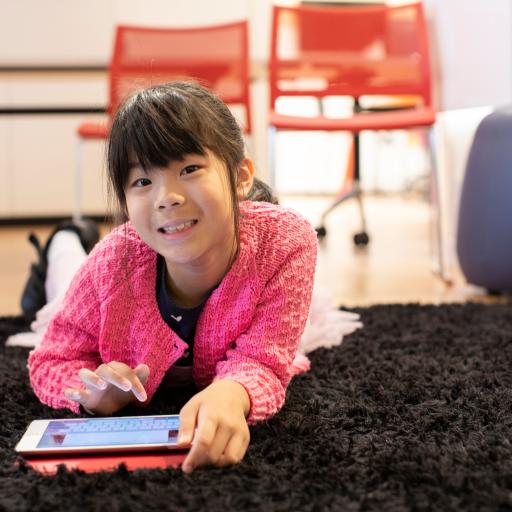 A girl lying down with an ipad